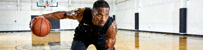 篮球运动员在训练馆进行个人特训，汗水淋漓，神情专注